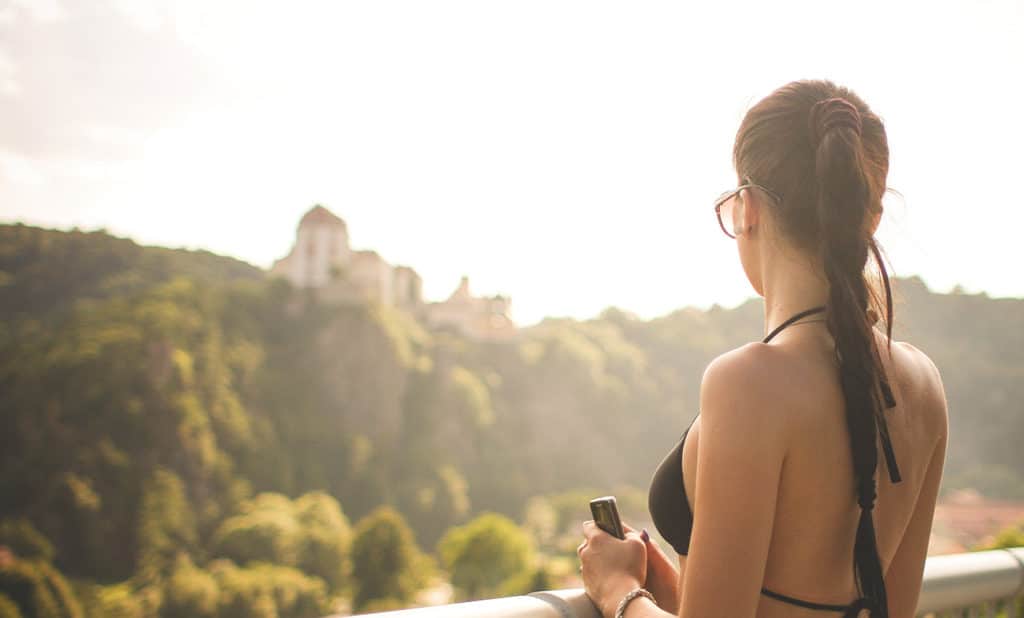 woman looking away in a beautiful but blurred view of mountains with castle