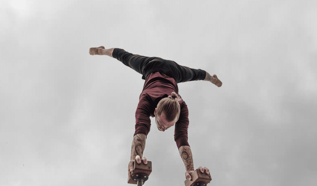 Coach Kyle Weiger doing a straddle handstand on an H-shape Canes Trainer with Cloudy Sky Background