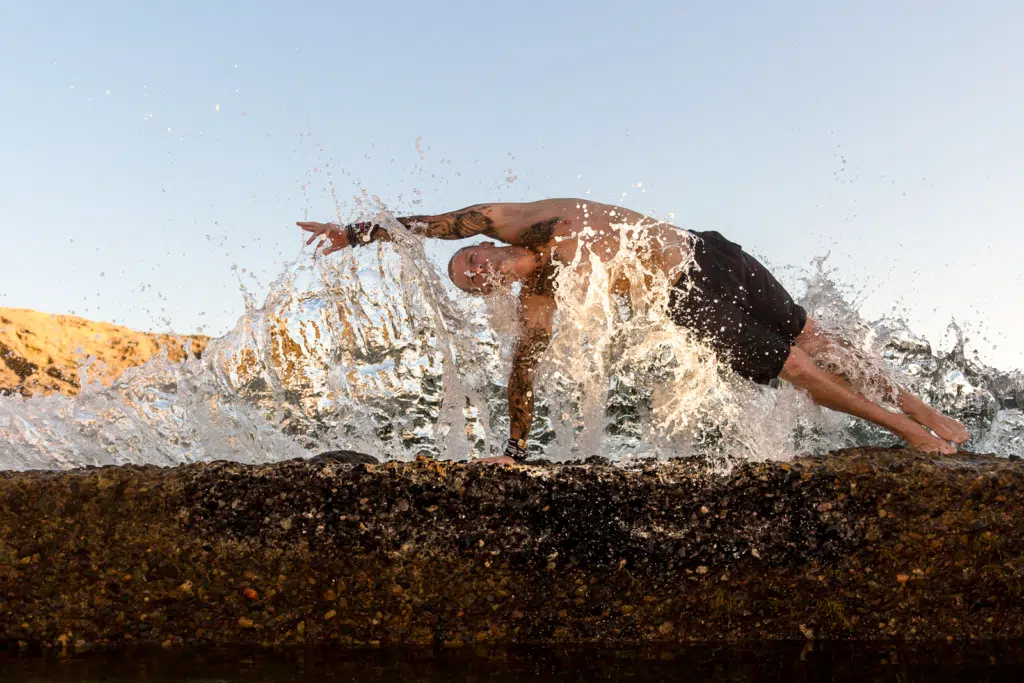 Coach Kyle Weiger doing a Sideplank at the side of the Beach