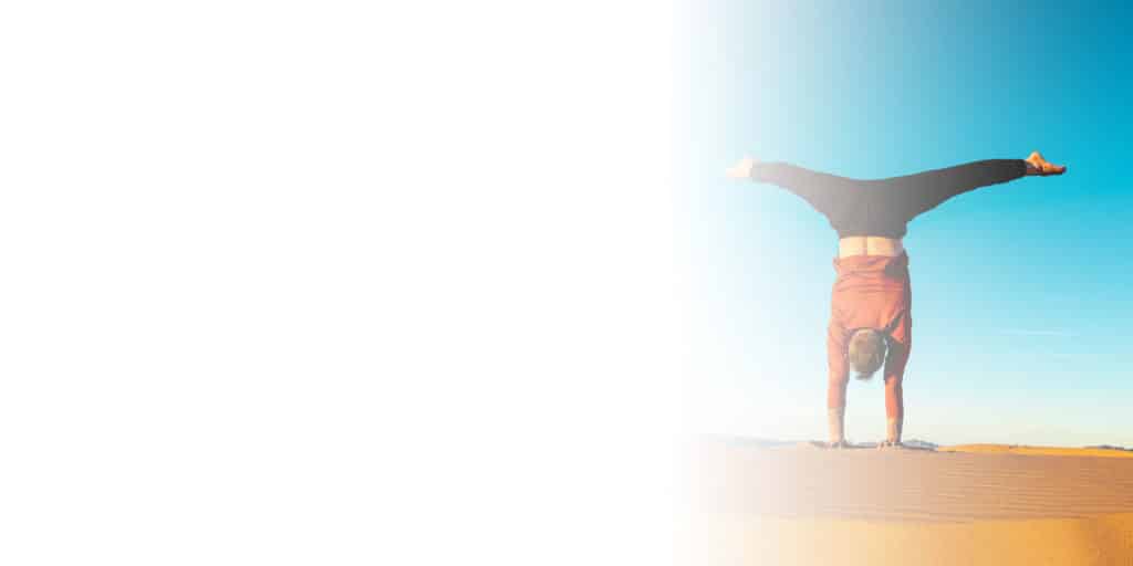 Faded picture from left to middle of Coach Kyle Weiger doing a handstand on the outdoor high altitude scenic dune background