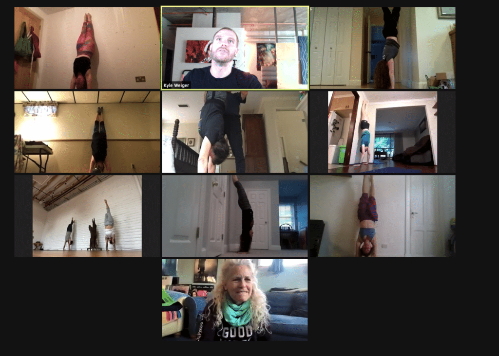 Coach Kyle Weiger on a class meeting with students doing a handstand
