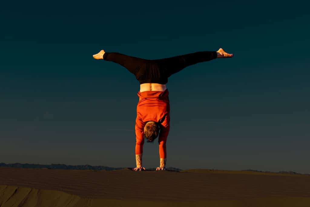 Coach Kyle Weiger doing handstand back facing with outdoor high altitude scenic dark background
