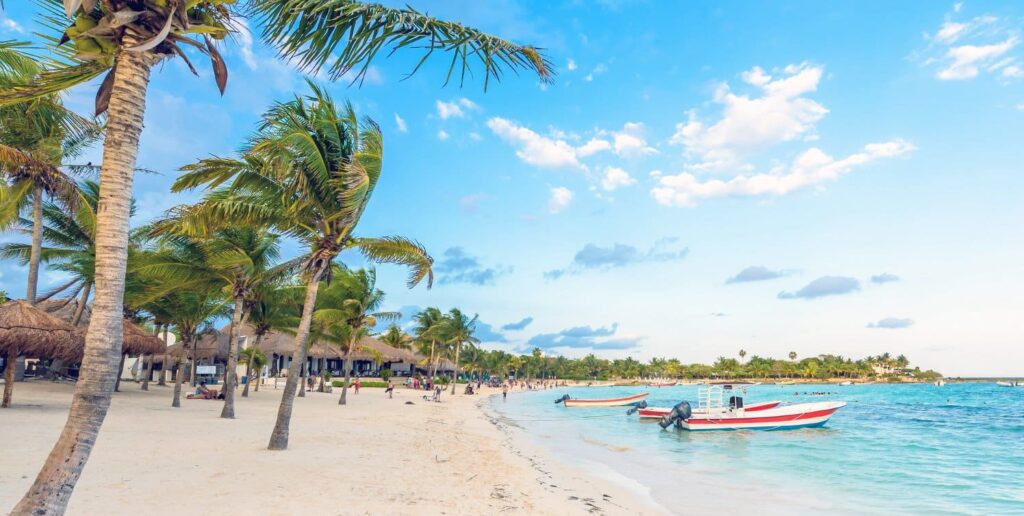 Tulum Beach Seashore with coconut trees boats and cottages
