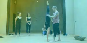 Handstand Coach working with student while other watch.